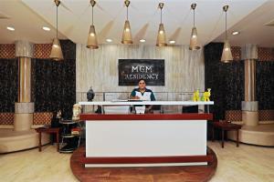 新德里Hotel MGM Residency at Daryaganj的站在餐厅柜台后面的女人