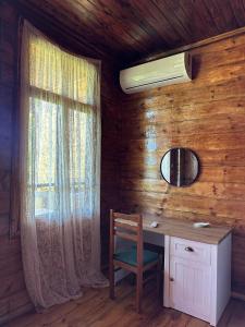 P'arts'khanaqaneviKutaisi airport guesthouse的木制客房设有书桌和窗户。