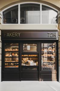 雅典Ergon Bakehouse Athens的面包店前面有女人在窗口