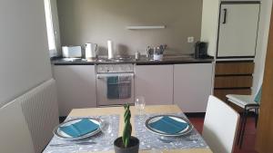 TrinCasa Crap的厨房里设有一张桌子,上面有蓝色的盘子和植物