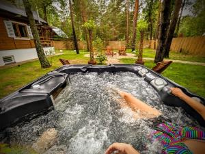 ArciechowSzumiąca Sosna - Jacuzzi, Ognisko, BBQ的两人在后院的游泳池游泳