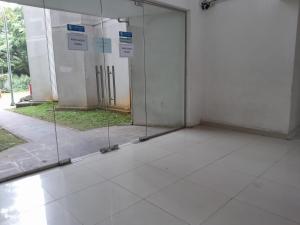 当格浪SMART INN Aeropolis Airport Soekarno Hatta的建筑中一个空房间,有玻璃门