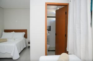 佩尼多Aconchego Fabuloso的一间卧室配有一张床,一扇门通往浴室