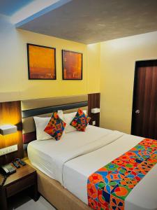 孟买Hotel Regal International - Near Mumbai International Airport Andheri East的一间卧室配有一张大床和色彩缤纷的毯子