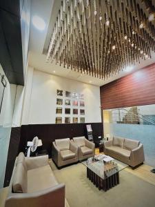 孟买Hotel Regal International - Near Mumbai International Airport Andheri East的大堂配有沙发、桌子和吊灯