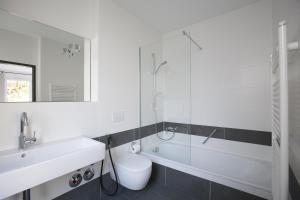 美因茨罗莫沃尔酒店的一间带水槽、卫生间和玻璃淋浴间的浴室