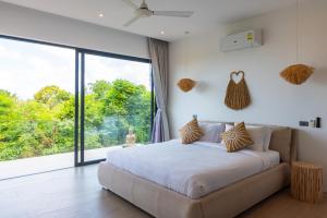 苏梅岛Ocean Dream 3Br Boho Chic & Private Pool Sea View的一间卧室设有一张床和一个大窗户