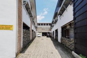 棉兰Alfalah Residence Syariah Mitra RedDoorz的一座空洞的小巷,在一座建筑物里停着一辆汽车