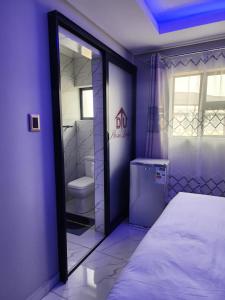 肯普顿帕克Duplessis Lodge的紫色的客房配有一张床和一个卫生间