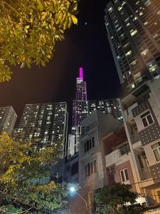 胡志明市Feli Home - Close to Landmark 81的一座高大的建筑,晚上有粉红色的灯光