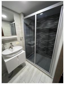 库塔伊西Crown Hotel的一间带玻璃淋浴和水槽的浴室
