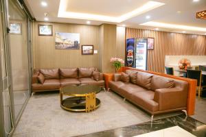 胡志明市Golden Dragon Hotel Sai Gon的一间设有真皮沙发和茶几的等候室