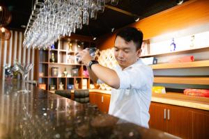 胡志明市Golden Dragon Hotel Sai Gon的一个人站在餐厅里的酒吧里