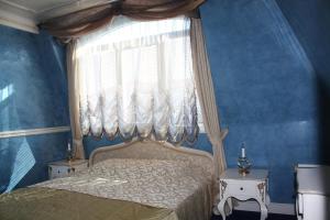 丘斯滕迪尔Hotel Lazur的一间卧室设有蓝色的墙壁和一张带窗户的床