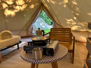 圣利法尔Grand tepee glamping pour 2的帐篷前配有桌子和咖啡设施