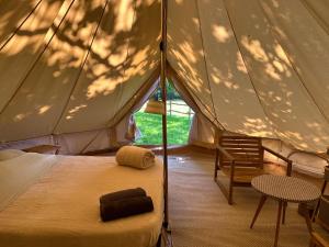 圣利法尔Grand tepee glamping pour 2的一间卧室配有带一张床和椅子的帐篷