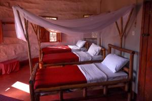 MakuyuniMaasai Eco Boma & Lodge - Experience Maasai Culture的一间卧室配有三张双层床。