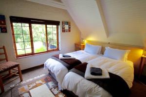 德尔斯特鲁姆Delagoa Cottage Dullstroom的一间卧室配有两张大床和毛巾