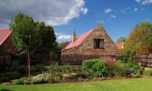 德尔斯特鲁姆Delagoa Cottage Dullstroom的院子里有红色屋顶的石头房子