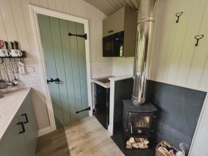 DarowenMid Wales Luxury Huts的客房内的厨房配有燃木炉