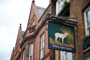 纽马基特White Hart, Newmarket by Marston's Inns的建筑一侧白色帽子酒店标志