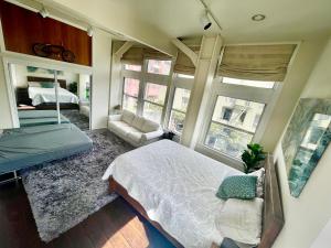 旧金山LUXE Lower Nob Hill Penthouse - Sleeps 6的一间卧室配有一张床、一张沙发和窗户。