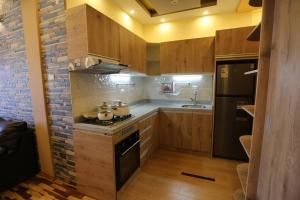 普诺Mini Departamento - Apu Cancharani的厨房配有木制橱柜和炉灶烤箱。