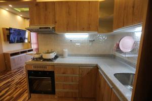 普诺Mini Departamento - Apu Cancharani的厨房配有木制橱柜和炉灶烤箱。
