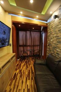 普诺Mini Departamento - Apu Cancharani的带沙发、电视和桌子的客厅