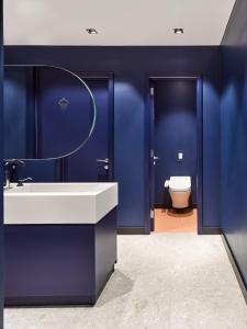 里加Kepler Club Riga Airport Hotel - Landside的蓝色的浴室设有水槽和卫生间