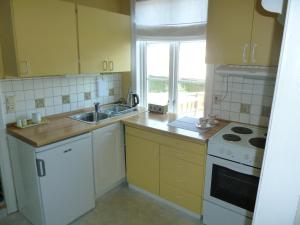 特罗姆瑟瑞德欧德豪斯特罗姆瑟公寓的厨房配有黄色橱柜、水槽和窗户。