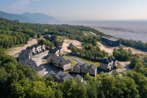 圣弗朗索瓦小河Chalets Grande-Pointe au Massif de Charlevoix -Vélos - Rando -ski-in ski-out的水边山丘上房屋的空中景观