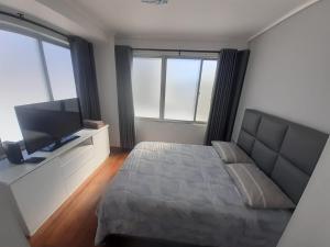 科恰班巴Lujoso departamento en ¨torre Alessandria¨的一间卧室配有一张床和一台平面电视