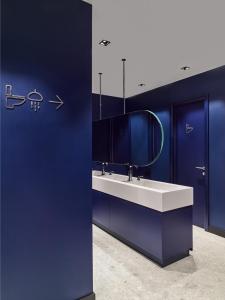 里加Kepler Club Riga Airport Hotel - Landside的蓝色的浴室设有水槽和镜子