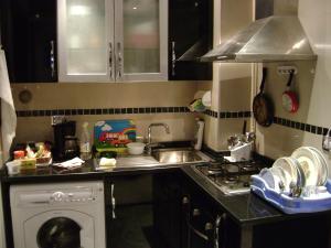 甘达坞伊港Studio Résidence Neptune Sousse Zone Kantaoui的厨房配有水槽和洗衣机