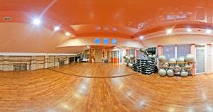 尼古拉耶夫印古尔酒店的一间空的健身房,铺有木地板,并设有一个保龄球馆
