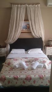 兹拉马Hotel Villa Tasko的一张带两条白色毛巾和鲜花的床