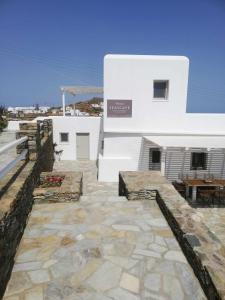Áno MeriáSeascape, Suite 5 with sea view的白色的建筑,设有石头庭院和桌子