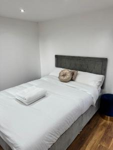 特威克纳姆Twickenham Stadium Condo的一张配有白色床单和枕头的大床