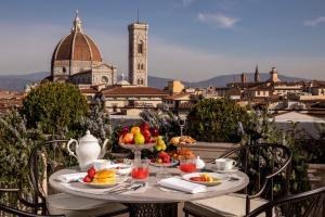 佛罗伦萨Tivoli Palazzo Gaddi Firenze Hotel的一张桌子,上面放着食物,享有城市美景