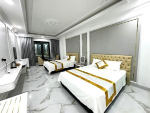 奠边府市Đông Thắm Hotel的酒店客房设有两张床和盥洗盆