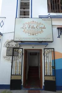 蓬蒂切里LA VILLA CREOLE的一座带读书小别墅标志的建筑