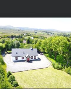 莱特弗拉克Red Deer Cottage near Connemara National Park in Letterfrack的享有带车道的白色房屋的空中景致