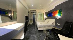 哥印拜陀Hotel Vijay Elanza的卧室配有一张床、一张桌子和椅子