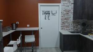 波图加莱特Albergue Bide-Ona的厨房设有一扇门,通往带椅子的厨房