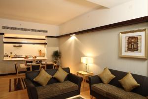 阿布扎比勒阿拉伯公寓式酒店的一间带两张沙发的客厅和一间用餐室