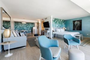 圣胡安Condado Palm Inn San Juan, Tapestry Collection by Hilton的酒店客房配有一张床、一张沙发和椅子。