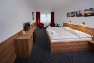 瓦拉什斯凯梅济日奇Sport HOTEL Centrum的一间卧室配有一张床和一张书桌及电视