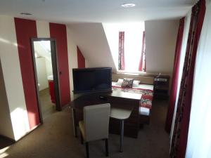 海德克塞博德斯穆旅馆的酒店客房配有书桌、电视和床。