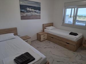 波弗加纳MiMa apartments island Pag,Povljana的一间卧室设有两张床和窗户。